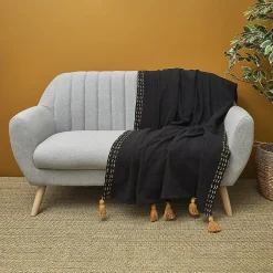 The Home Deco Factory Jeté de canapé surpiqué pompons noir 130x150 cm